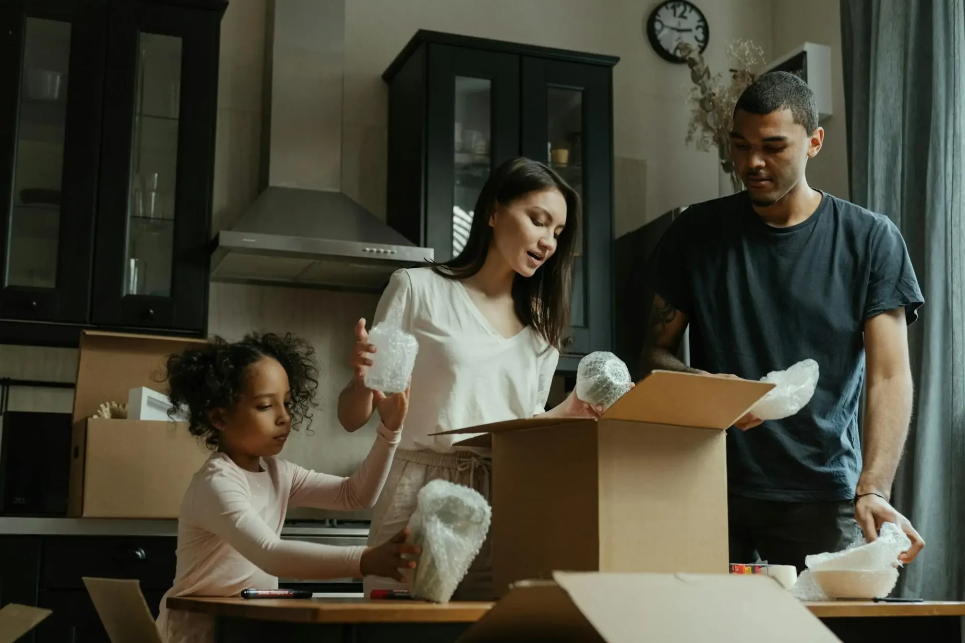 family unpacking moving boxes